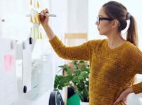 カレンダーを見つめて悩む女性