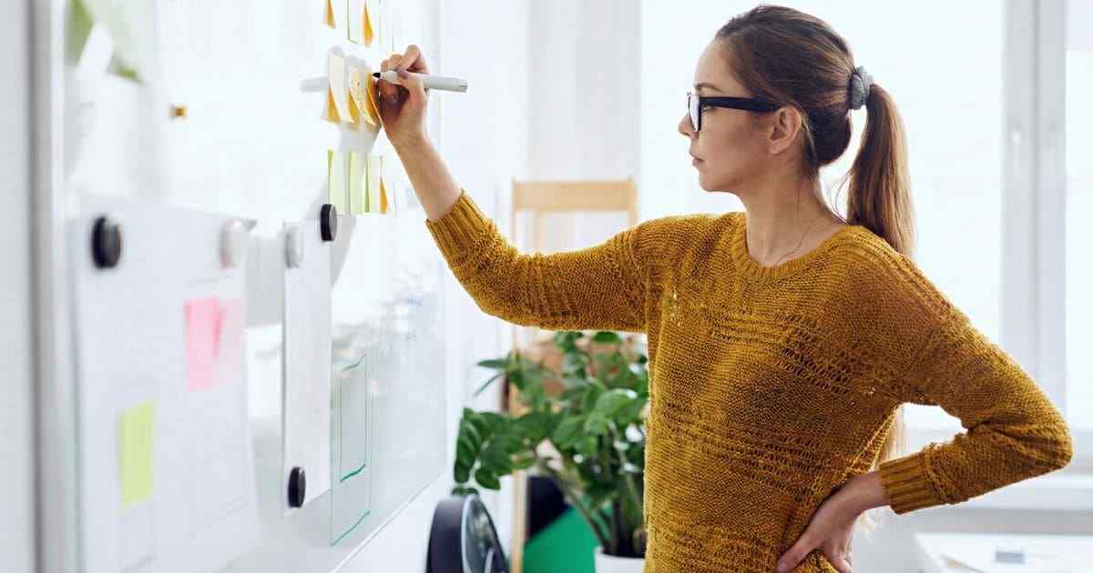 カレンダーを見つめて悩む女性